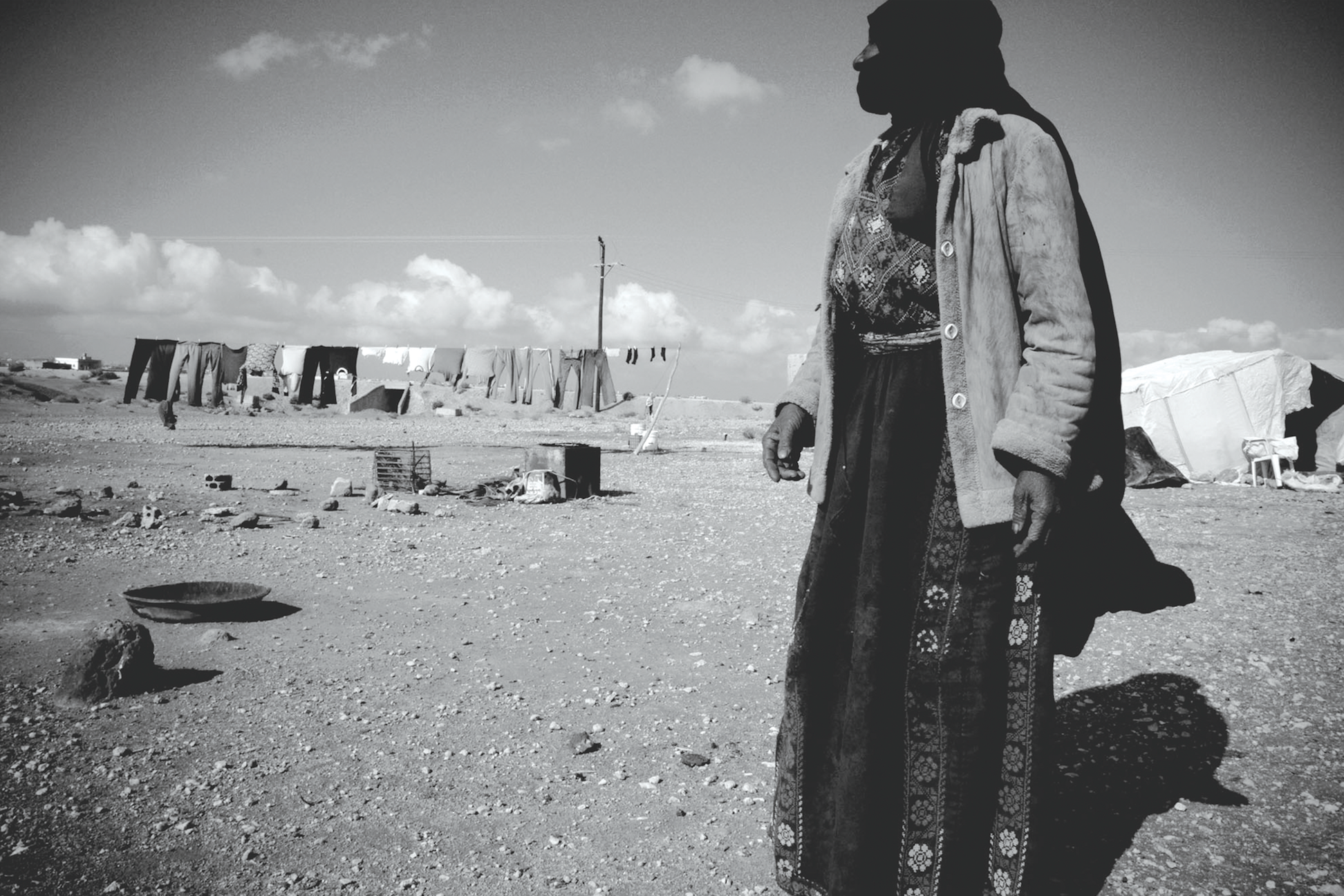 A Bedouin woman walks out into the open expanse of the Jordanian desert where she awaits food aid brought by the Near East Foundation. Jordan 2007. | photo by Joshua Zirschky